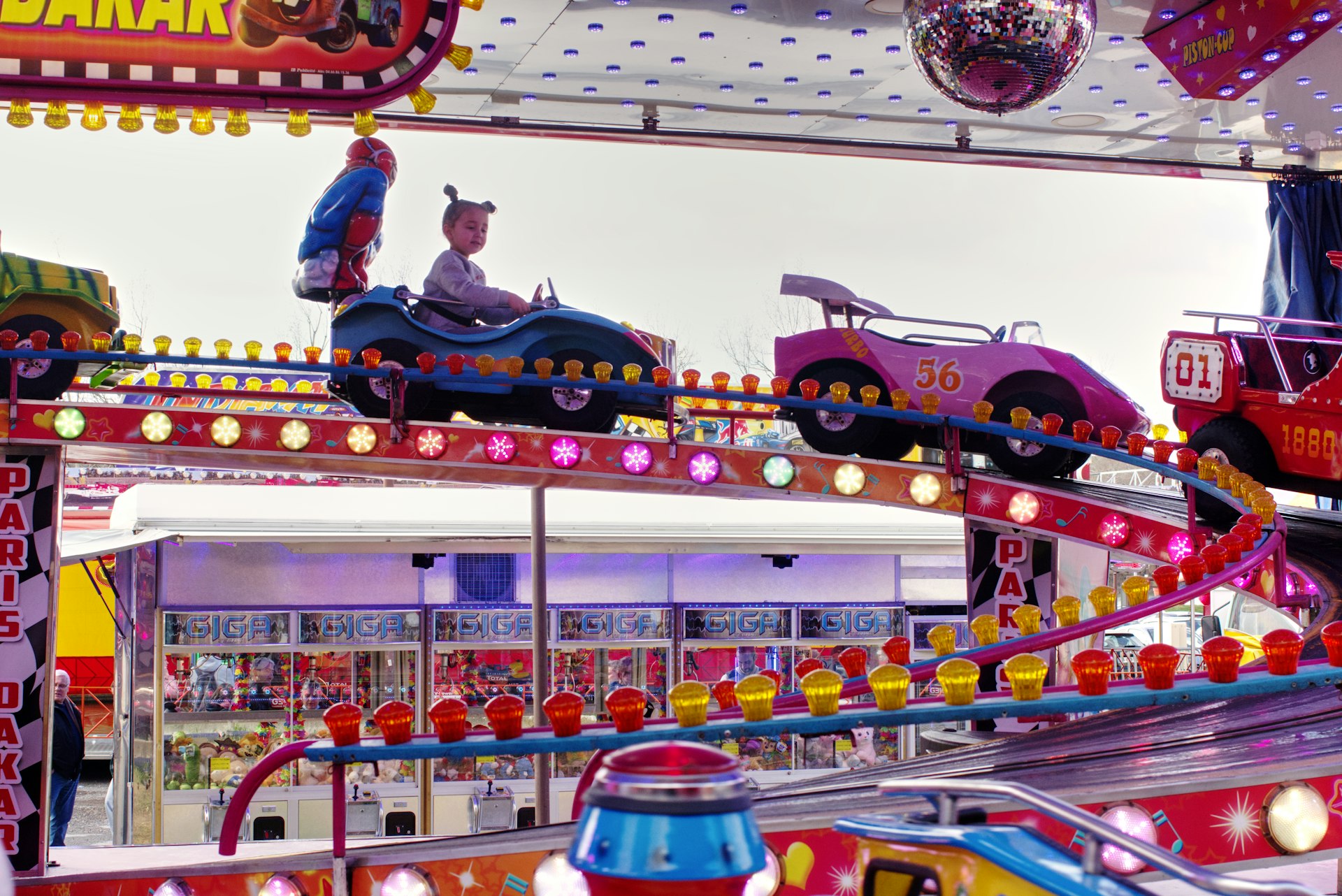 a carnival ride with a man riding a toy car