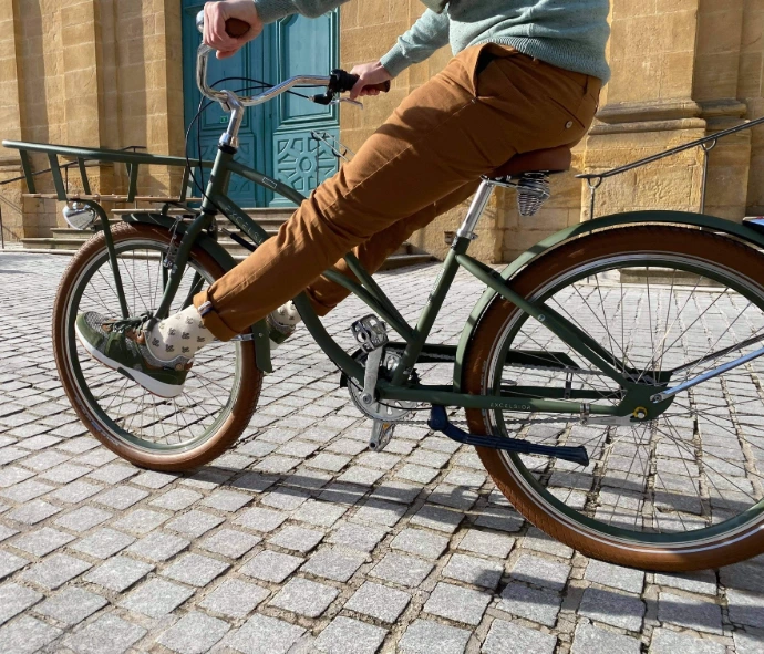 Photo d&#39;un cycliste sur les pavé d&#39;une rue de Metz avec des baskets de chez Continuum