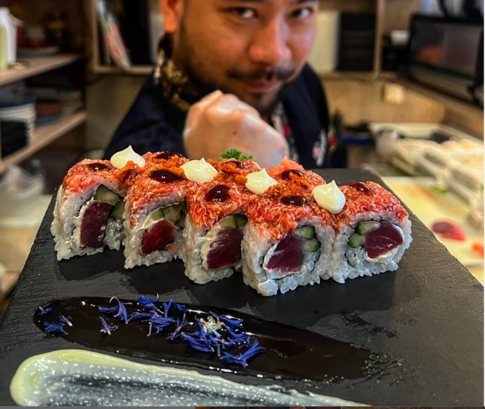 Serveur tendant un plat de sushis