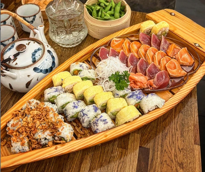 très beau plat de sushis sur une assiette en forme de bateau